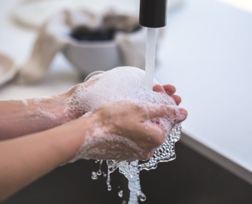 Washing hands in sink with soap to kill germs