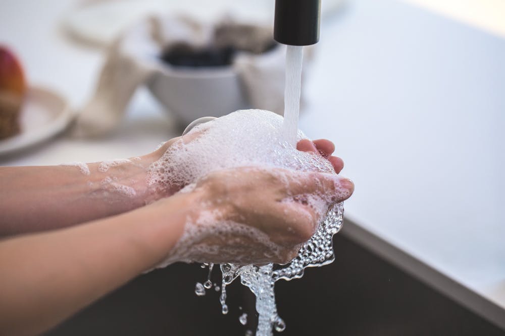 Washing hands with soap in sink to kill germs